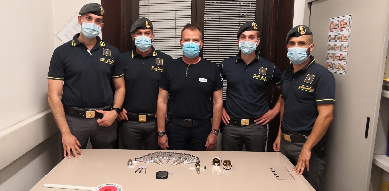 i militari della guardia di finanza con le sostanze sequestrate appoggiate sul tavolo