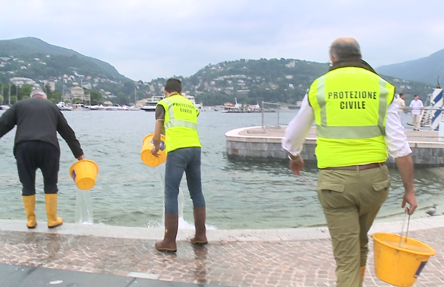 Lungolago allagato. La risposta dei sindaci a Rapinese, in piazza armati di secchiello: “Ma Como non vuole collaborare”
